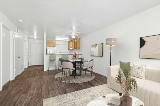 Spacious living area in 1 Bed 1 Bath B apartment home with wood-style plank flooring and an open concept layout leading to the dining area.