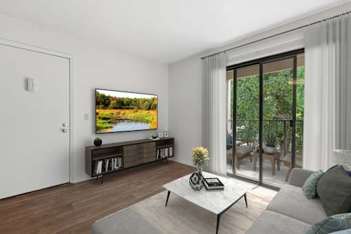 Living Room in 1 Bed 1 Bath A floor plan at California place apartments with wood-style plank flooring, and large sliding doors leading to a private balcony surrounded by lush trees providing a beautiful view and cozy feel