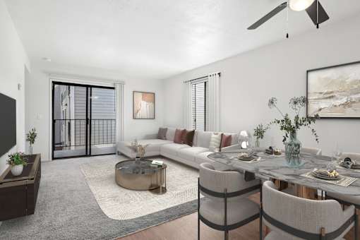 Spacious living area in 2 Bedroom California place apartment home with plush carpeted flooring and large sliding doors leading to private patio/balcony. Open concept floor plan layout leads to the dining nook with wood-style plank flooring and a ceiling fan