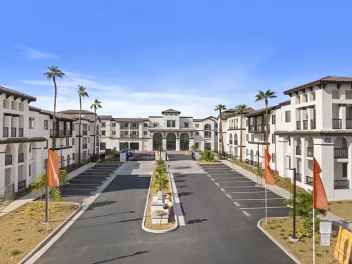 an empty street in front of apartments with palm trees