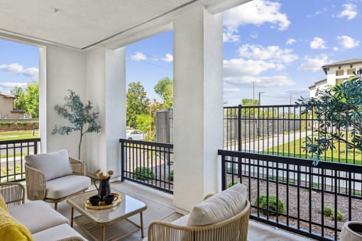 a living room with two couches and a table on a balcony
