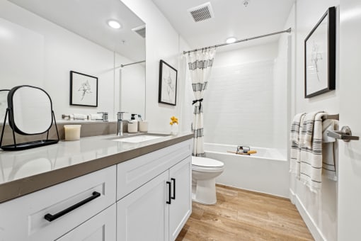 a white bathroom with a shower toilet and sink