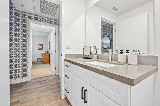 a large white bathroom with a sink and a mirror