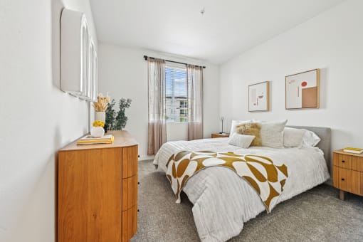 a bedroom with a bed and a dresser and a window