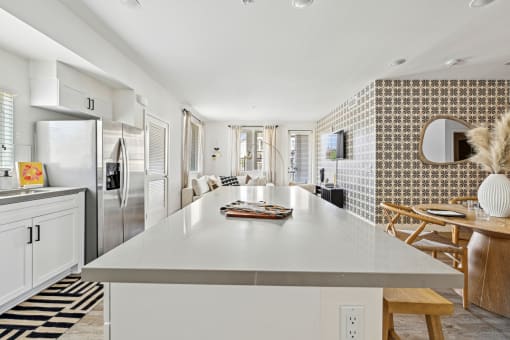 a kitchen with a white counter top and a stainless steel refrigerator