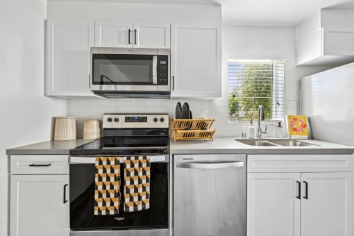 a modern kitchen with white cabinets and stainless steel appliances