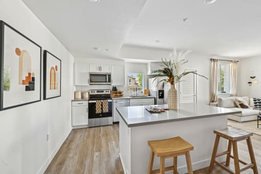 an open kitchen and living room with an island and stools