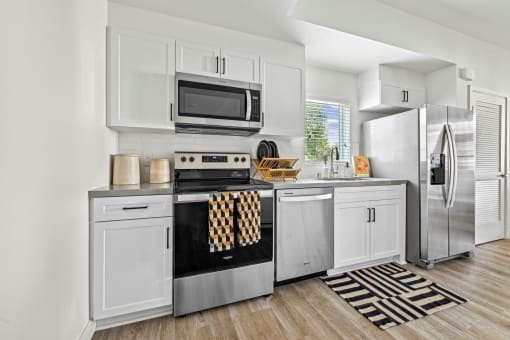 a kitchen with stainless steel appliances and white cabinetry