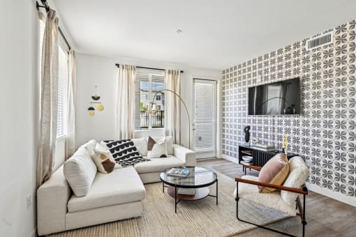 a living room with a couch and a chair and a television