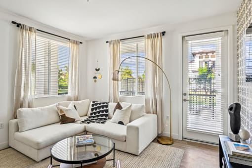 a living room with a white couch and a glass coffee table