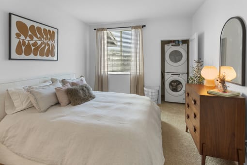 a bedroom with a bed and a washer and dryer