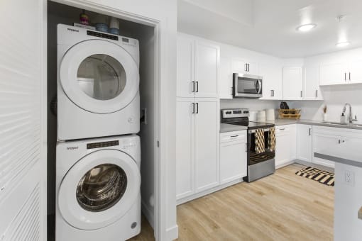 a white kitchen with a washing machine and a washer and dryer in it