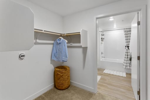 a bathroom with a closet and a shower and a basket on the floor
