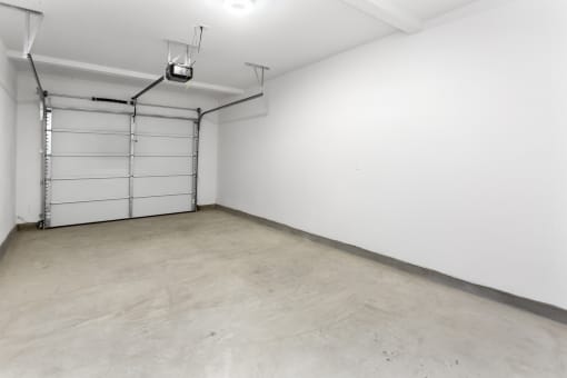 an empty room with a white wall and a garage door