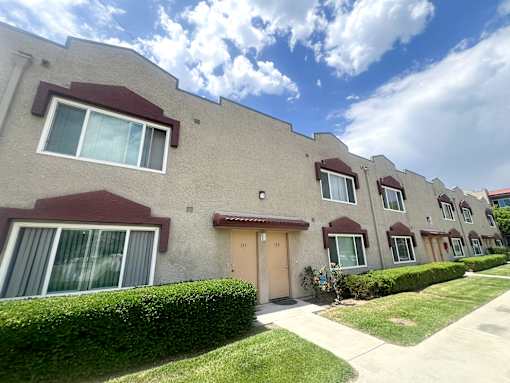 Azusa Gardens Apartment exterior surrounded by grass-lined walkways
