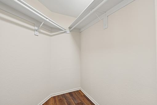Oversized closet in Cielo apartment home with plank flooring, built in shelving and hanging racks