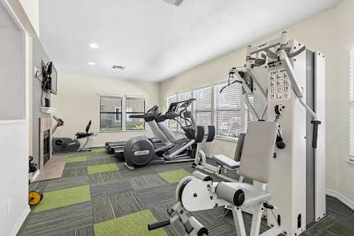 Fitness Center at California Place Apartments with plenty of equipment and large windows allowing for gorgeous natural lighting