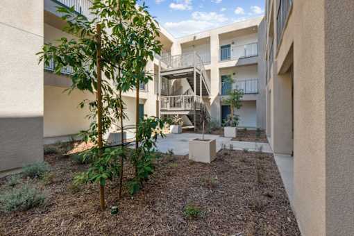 Courtyard with landscaping and residential balconies at Altitude Apartments, Moreno Valley, California