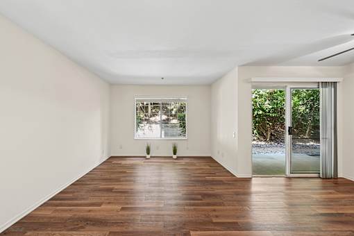 Oversized living area in Cielo apartment home with plank flooring, large windows and sliding doors leading to private patio