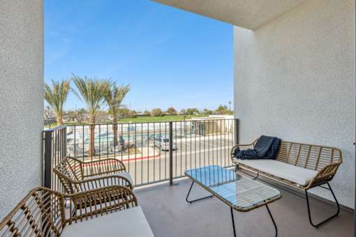 Balcony with seating overlooking pool and greenery at Altitude Apartments, California, 92553
