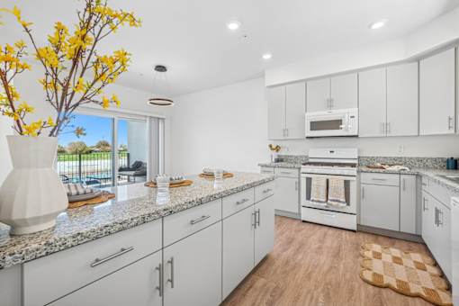 Modern kitchen with granite countertops and white cabinets at Altitude Apartments, Moreno Valley, CA 92553