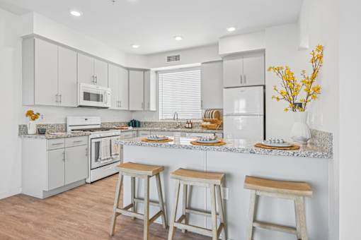 Bright kitchen with breakfast bar and stools at Altitude Apartments, Moreno Valley, 92553