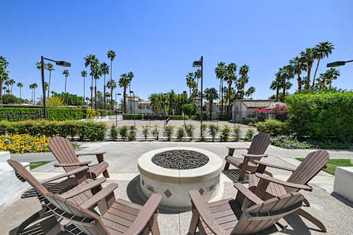 A fire pit surrounded by chairs in a garden.