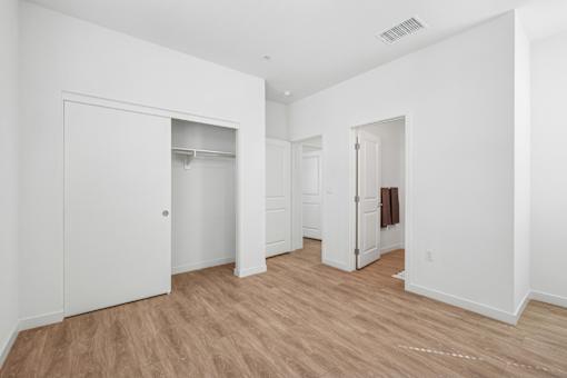 Bedroom with walk-in closet and hardwood flooring at Altitude Apartments, Moreno Valley, CA 92553