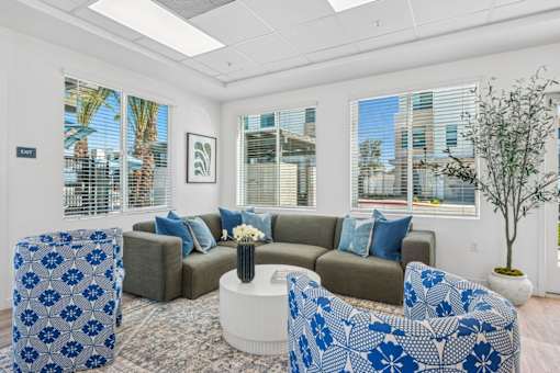 Community lounge with curved seating and blue accent chairs at Altitude Apartments, Moreno Valley, CA