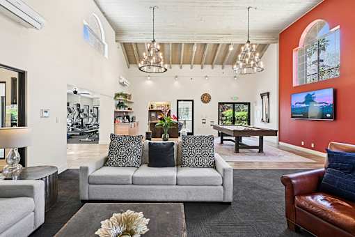 A living room with a grey couch and a brown leather chair.