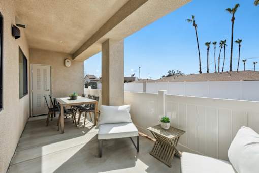 Covered patio with outdoor dining and lounge seating at Altitude Apartments, Moreno Valley, CA