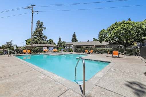 Luxurious swimming pool at Bent Tree surrounded by chaise lounges and dining tables for the ultimate poolside experience.