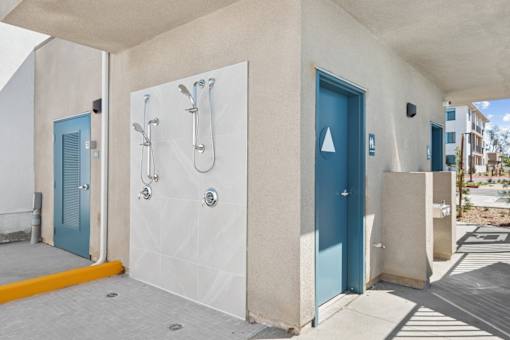 Outdoor shower facilities with restroom access doors at Altitude Apartments, California