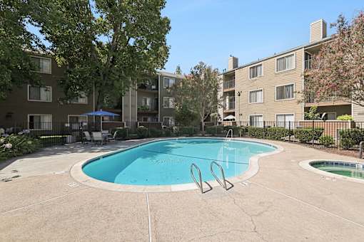 A swimming pool in a courtyard surrounded by buildings.