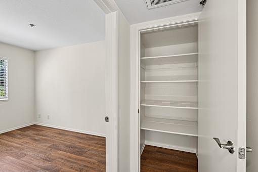 Bedroom inside Cielo Apartment home with plank flooring and large windows allowing for gorgeous natural lighting