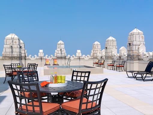 A table with chairs is set up on a rooftop terrace.