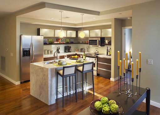 A modern kitchen with a marble island and stainless steel appliances.