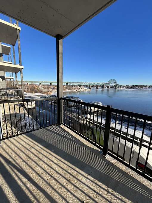 a balcony with a view of a river and a bridge