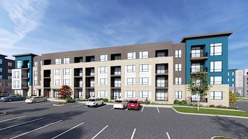 A modern apartment complex with a parking lot in front.