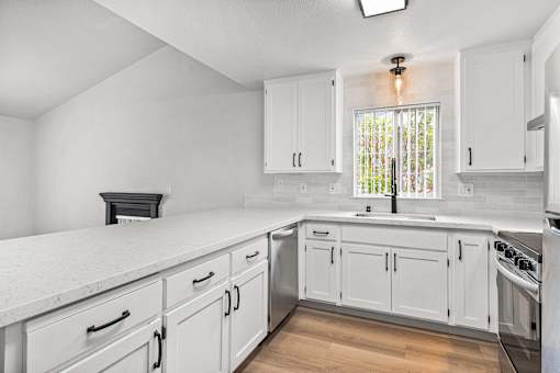 A white kitchen with lvp floors and white cabinets.