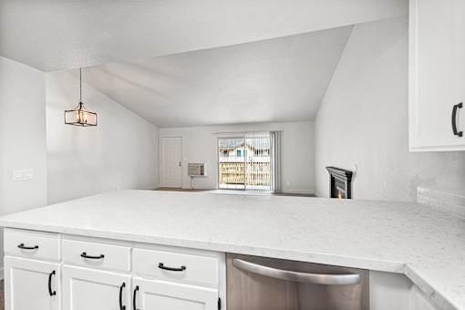 A kitchen with white cabinets and a quartz countertop.