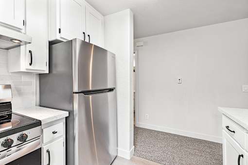A kitchen with a stainless steel refrigerator and oven.