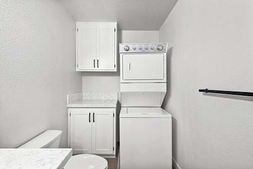 A white washing machine and dryer in bathroom