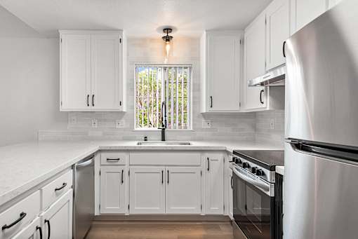 A kitchen with white cabinets and stainless steel appliances.