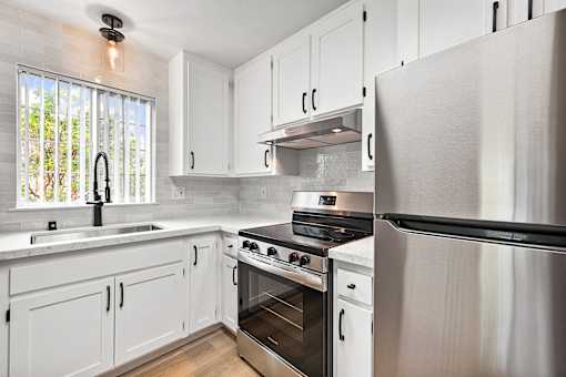 A kitchen with white cabinets and stainless steel appliances.
