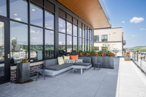 A patio with a couch and a table with a view of the city.