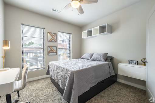 a bedroom with a bed and a desk with a chair at 1400 Russell Apartments, Saint Louis, MO, 63104
