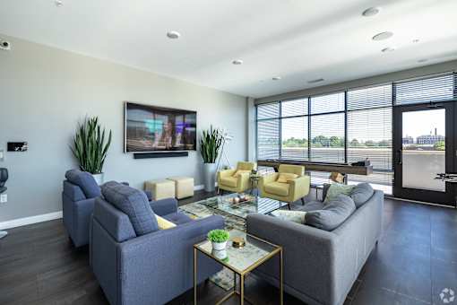a living room with couches and chairs and a television on the wall at 1400 Russell Apartments, Missouri