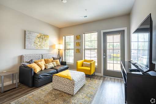 a living room with a couch and a chair and a tv at 1400 Russell Apartments, Saint Louis, 63104