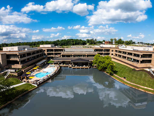 A large building complex with a pool in the middle. at The Residences at Tesson Ridge Apartments, Saint Louis, Missouri